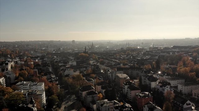 Wide aerial shot of the capitel of Hesse: Wiesbaden. The city in Germany is filmed by drone on a sunny morning. The cityscape can be seen against the blue sky. Light traffic is on the streets.