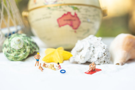 Miniature people, travelers relaxing on the sand box decorating in summer theme using as background travel, exploring the world, budget trip concept.