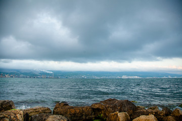 Fototapeta na wymiar Stormy clouds under the Black sea. Themes bay in Novorossiysk in Krasnodar region, Russia. Image of sea trading port