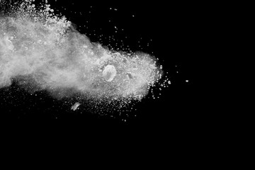 Obraz premium Freeze motion explosion of white powder on a black background.Stopping the movement of white dust on dark background.