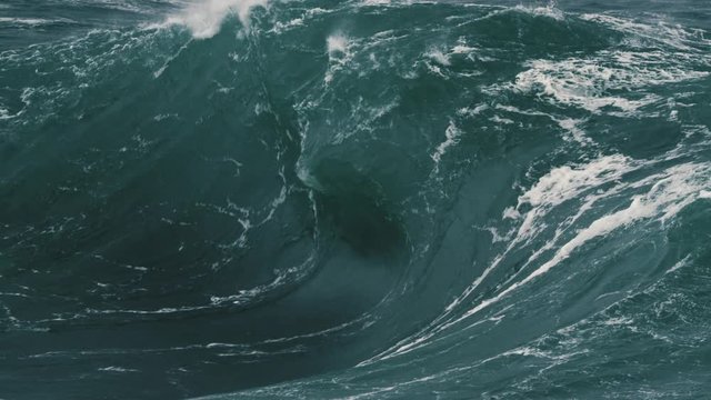 Large heavy wave breaking onto a shallow reef. Slow motion.