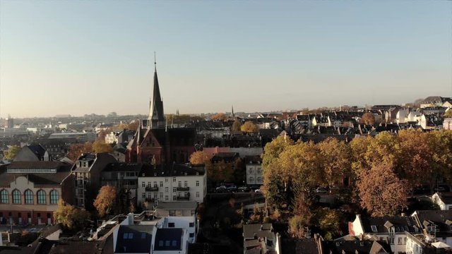 Flying above Wiesbaden: a group of doves are circuling around a drone on a sunny morning. The background is the capital of Hesse in Germany.