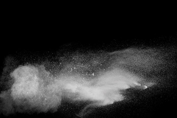 Freeze motion explosion of white powder on a black background.Stopping the movement of white dust...
