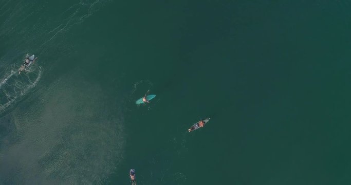 Aerial cenital cinematic shot of a surfers waiting and a surfer surfing a big tube barrel wave that creates a rainbow in Zicatela beach Puerto Escondido, Oaxaca