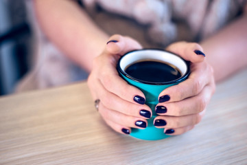 Fototapeta na wymiar Woman holding hands around cup with hot drink