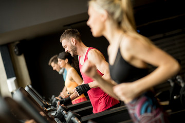 Fototapeta na wymiar young people running on treadmills in modern gym