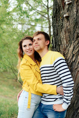 young couple in love in yellow clothes on nature against the background of a tree 1