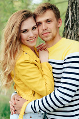 young couple in love in yellow clothes on nature against the background of a tree 1