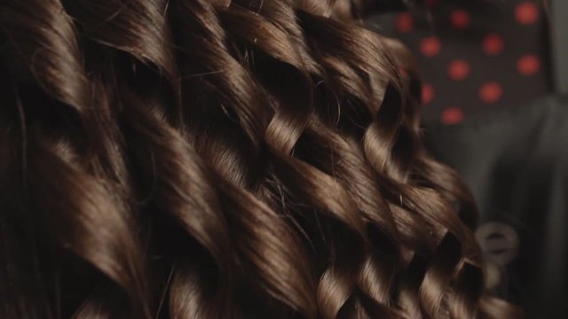 Hairstyling with iron in dynamic close up shot, slow motion