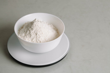 Fototapeta na wymiar Flour in a bowl is on a kitchen scale.