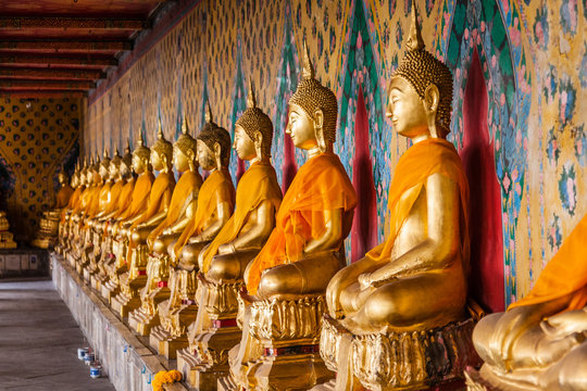 A gallery of the statues of dressed seated Buddhas in Wat Arun, Bangkok