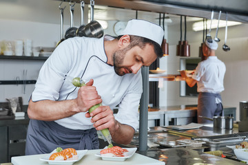 Delicious Served Fresh. Sushi master prepares sushi for serving in modern commercial kitchen