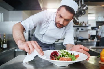 Food is our religion. Сook preparing dish for serving