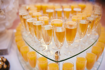 Glass of white wine on a table. Many glass wine in a row on bar counter. Glasses with wine. Filled with half and stand on the holiday table. Furshet.