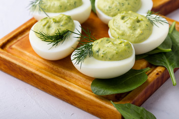 Deviled eggs with avocado and spinach on festive Easter table
