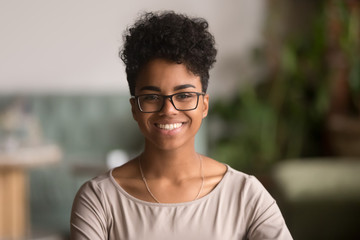 Headshot portrait of happy mixed race african girl wearing glasses
