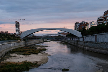 atardecer detrás del puente reflejado en el río