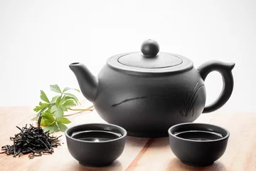 Foto op Aluminium Set for tea ceremony. Large clay  teapot, fresh green tea and cups. Front view. Copy space, space for text, isolated. © Nataliia