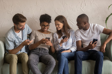 Happy diverse friends group sharing social media news holding phones