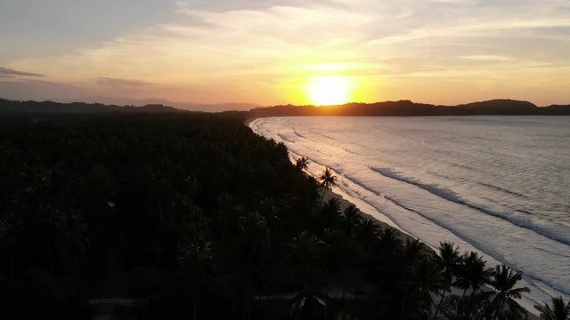 Fly over sea on long beach at sunset, San Vincente, Philippines