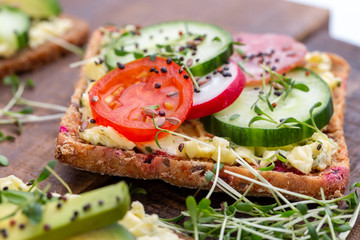 Sandwiches with cream cheese, vegetables and salami.