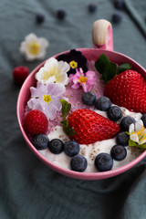 vegan pink and white chiapudding with strawberries, blueberries and flowers