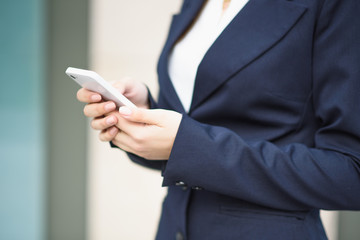The business lady uses a smartphone on the street