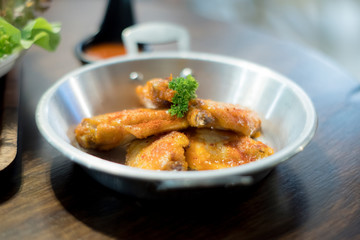 Homemade baked chicken in pan on wooden table. Top view