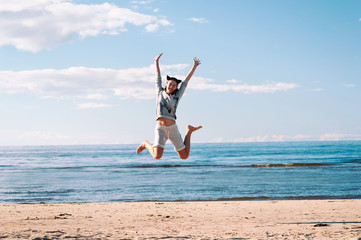 Young cheerful jumping teenage girl excitement at seaside
