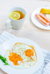 Fried eggs with  sausages and hot tea