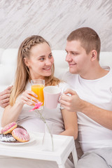 Obraz na płótnie Canvas Romantic happy couple having breakfast on the bed