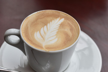 Coffee cup with latte art foam on wood table in coffee shop with copy space.Coffee is one of the most popular beverages.Improve Energy Levels and Burn Fat
