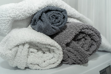 Close-up of clean folded cotton towels of gray shades on the washing machine in the bathroom