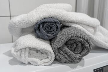 Clean folded cotton towels of gray shades on the washing machine in the bathroom