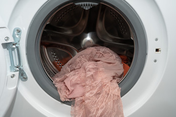 A pink lace dress just washed in an automatic washing machine, delicate wash mode 