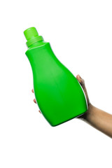 Female hand holding out blank green cleaning bottle at an angle on an isolated white background - Laundry detergent container held outwards by hand on a plain background with no brand