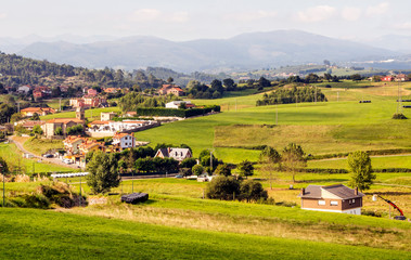 Fototapeta na wymiar Rural town in the meadows near the mountains in Asturias in the north of Spain in a sunny day