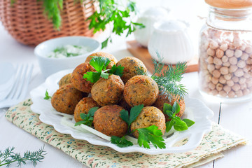 Chickpea falafel with fresh herbs on a white table, horizontal