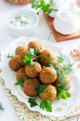 Chickpea falafel with fresh herbs on a white plate, selective focus