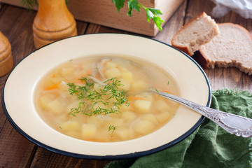 Transparent potato soup on the wooden table, horizontal