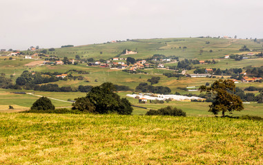 Rural town in the meadows near the mountains in Asturias in the north of Spain in a sunny day