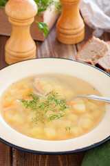 Transparent potato soup in meat broth, selective focus