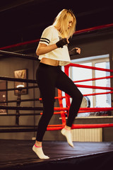 Boxer woman in boxing gloves in ring . Sexy sport blonde girl boxer posed in the ring. Fit woman boxing.