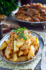 Sliced roasted mustard potatoes with grains, selective focus