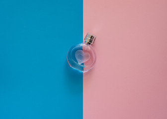 Top view perfume bottle isolated on pink and blue paper.