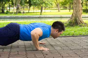 Man doing push up in park.