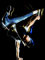 one chinese young man hip hop break dancer dancing isolated on black background with speed light...