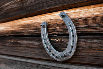 Old horseshoe on an old wooden board. The concept of luck, luck, luck. - obrazy, fototapety, plakaty
