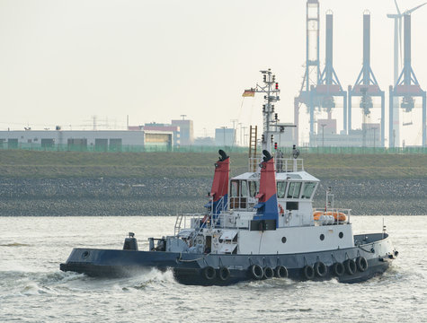 Hafenschlepper auf dem Weg zu einem Containerschiff um es zu schleppen 