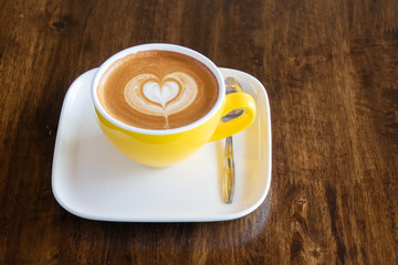 Coffee cup with latte art foam on wood table in coffee shop with copy space.Coffee is one of the most popular beverages.Improve Energy Levels and Burn Fat